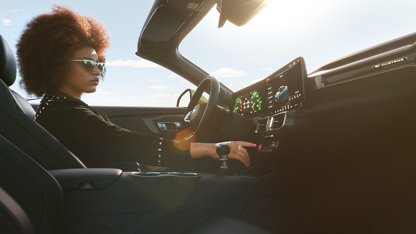 Ford Mustang Innenraum. Ansicht auf Instrumententafel und Frau im Fahrersitz.