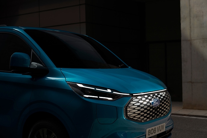 Ford E-Transit Custom in Blau. Detailansicht des eines Ladekabels, das am Fahrzeug angeschlossen ist.
